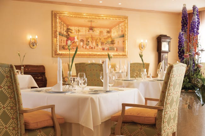 Restaurant dining area at the Hotel Bulow Palais with tables set up around the room and paintings on the walls