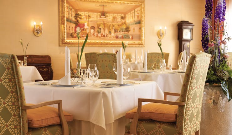 Restaurant dining area at the Hotel Bulow Palais with tables set up around the room and paintings on the walls