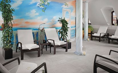 Hotel Bulow spa with white painted walls, reclining chairs with towels on and marble pillars