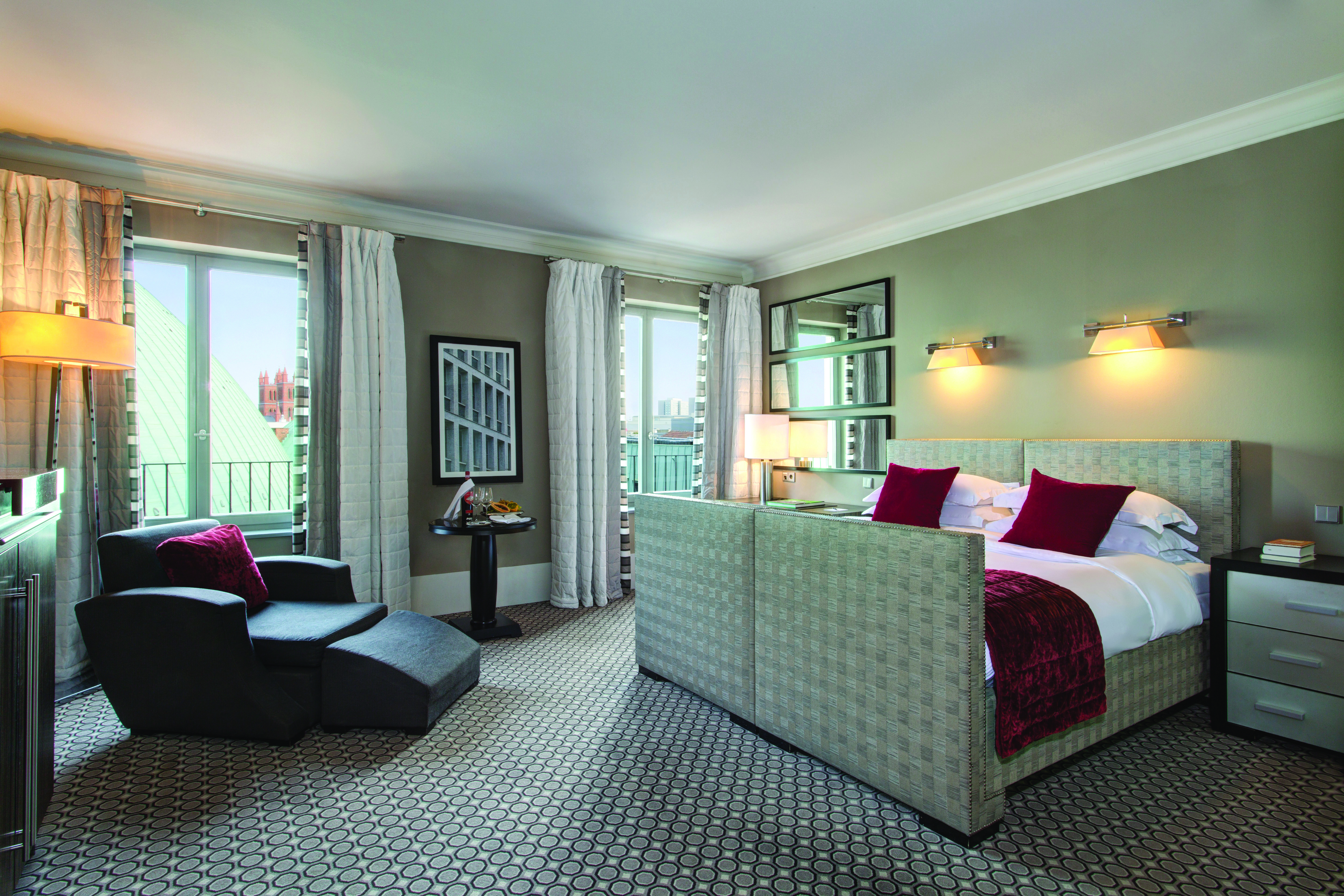 Hotel de Rome deluxe bedroom grey head board and foot board reclining armchair and large windows