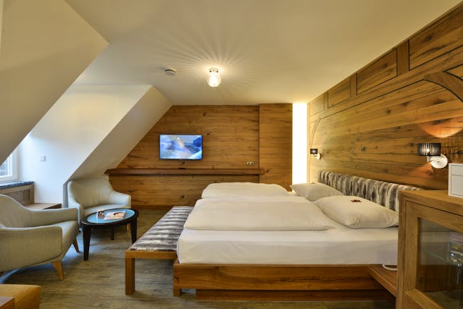 Hotel Torbrau Munich bedroom with wooden walls skylight window and two cream chairs