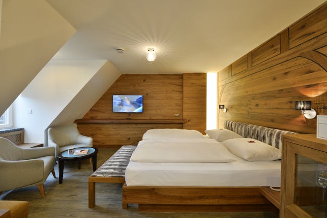 Hotel Torbrau Munich bedroom with wooden walls skylight window and two cream chairs