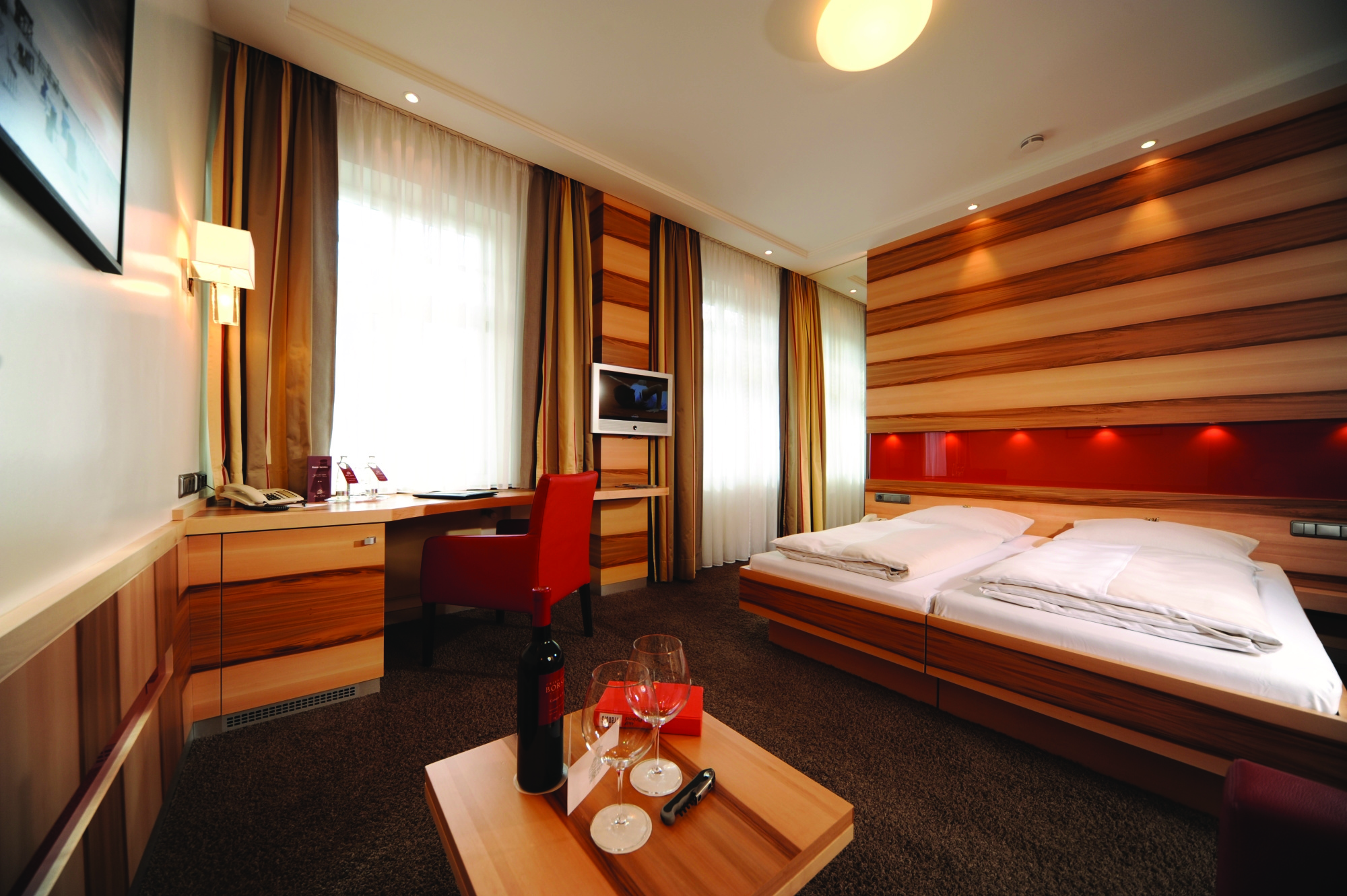 Hotel Torbrau Munich superior bedroom corner desk television and table with wine