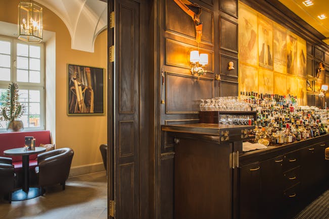 Taschenbergpalais bar, leather armchairs, wood panelling, bar filled with bottles, traditional decor