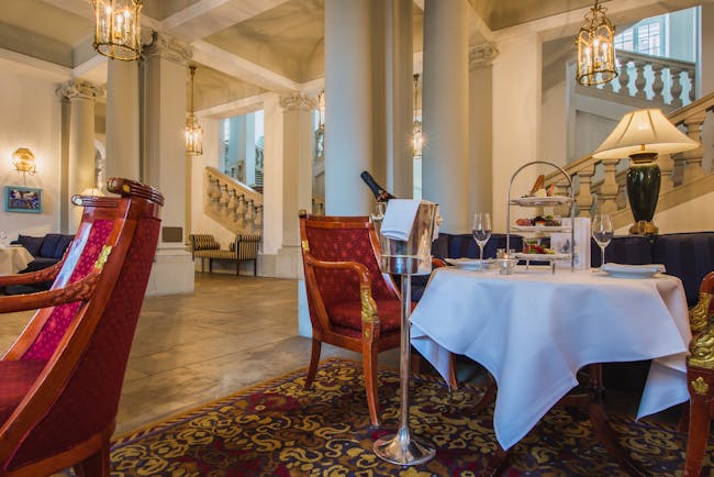 Taschenbergpalais cafe vestibul, indoor eating area, grand decor woth stone pilars and carbed staircase, table and chairs