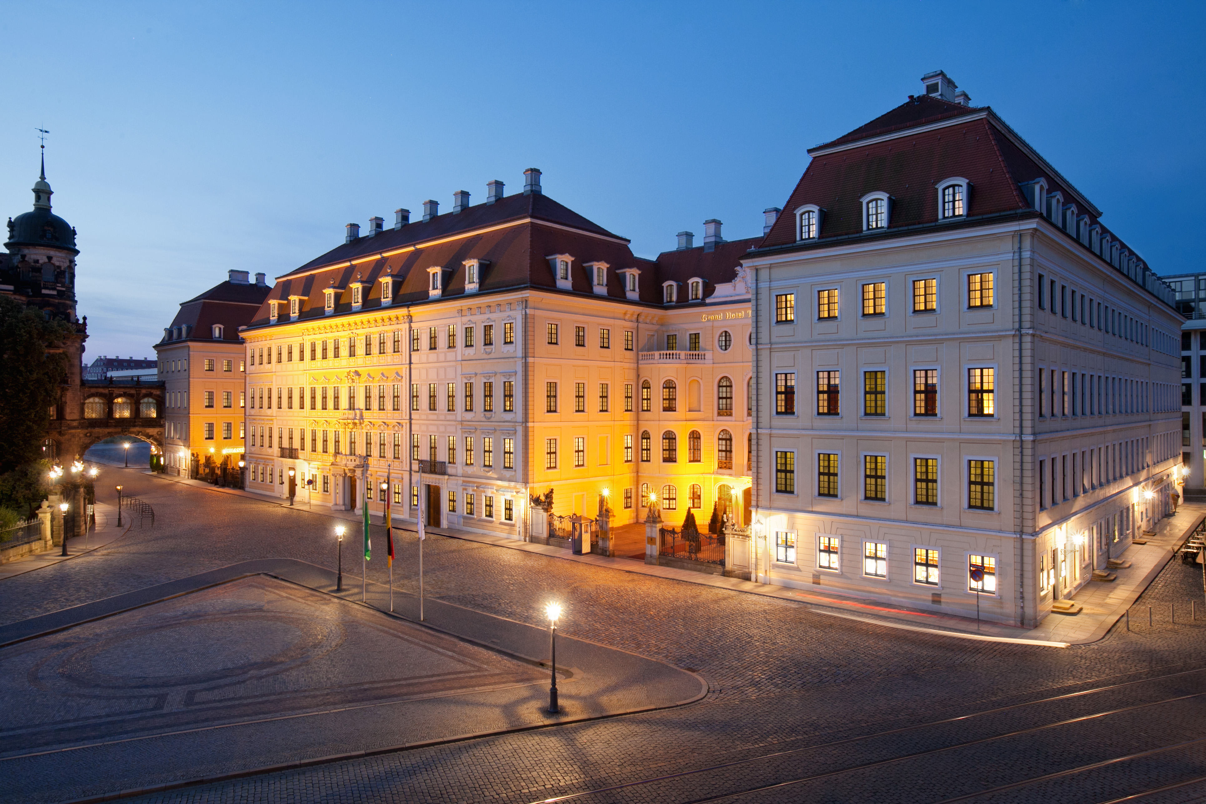 Exterior at night showing large white hotel building lit up with orange lights 