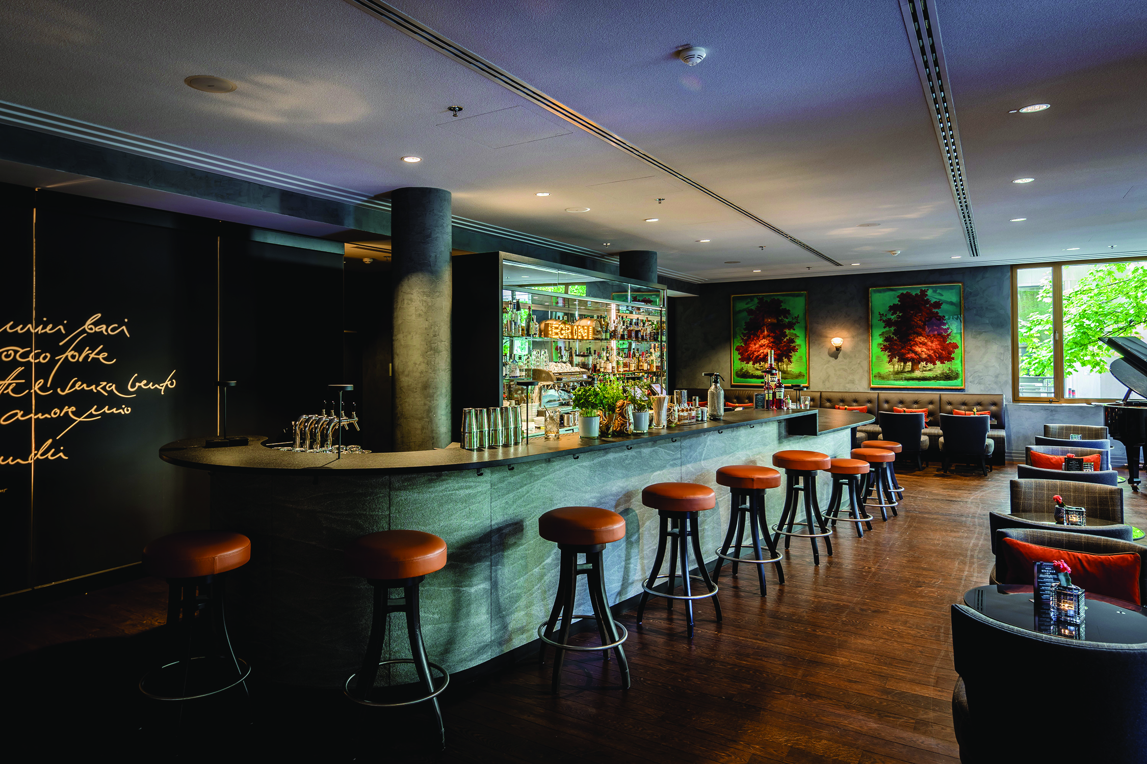 Bar at the Charles Hotel with dark wooden panneling, lether high bar seats and wooden floors