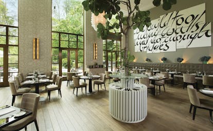 Dining area at the restaurant with high pannelled windows against the walls 