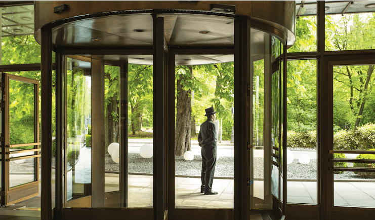 Revolving entrance doors to the hotel with butler standing outside to greet guests