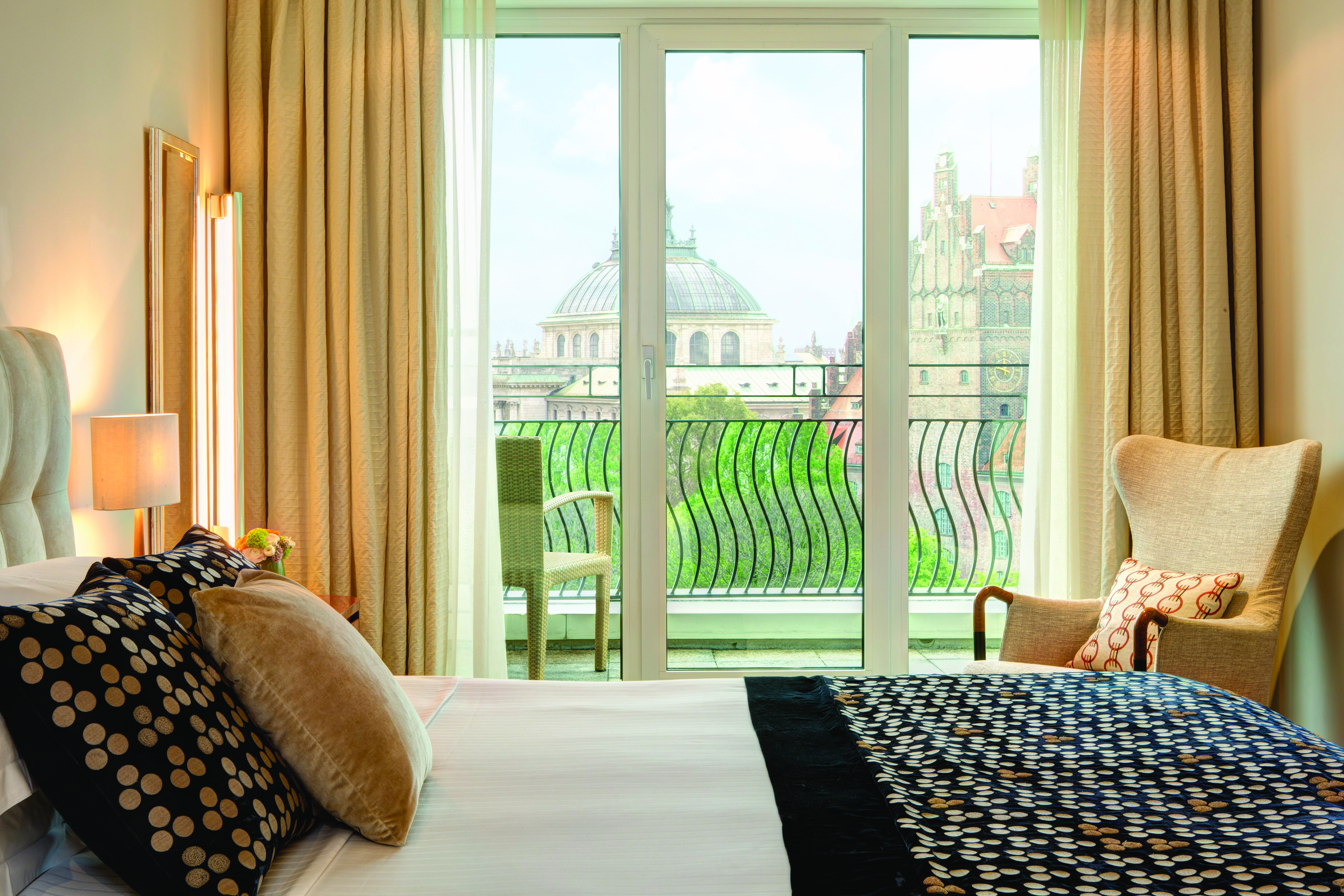 Monforte suite at the Charles Hotel with a large double bed, bifolding doors leading on to a balcony overlooking the city 