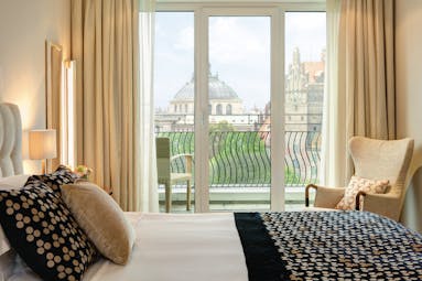 Monforte suite at the Charles Hotel with a large double bed, bifolding doors leading on to a balcony overlooking the city 