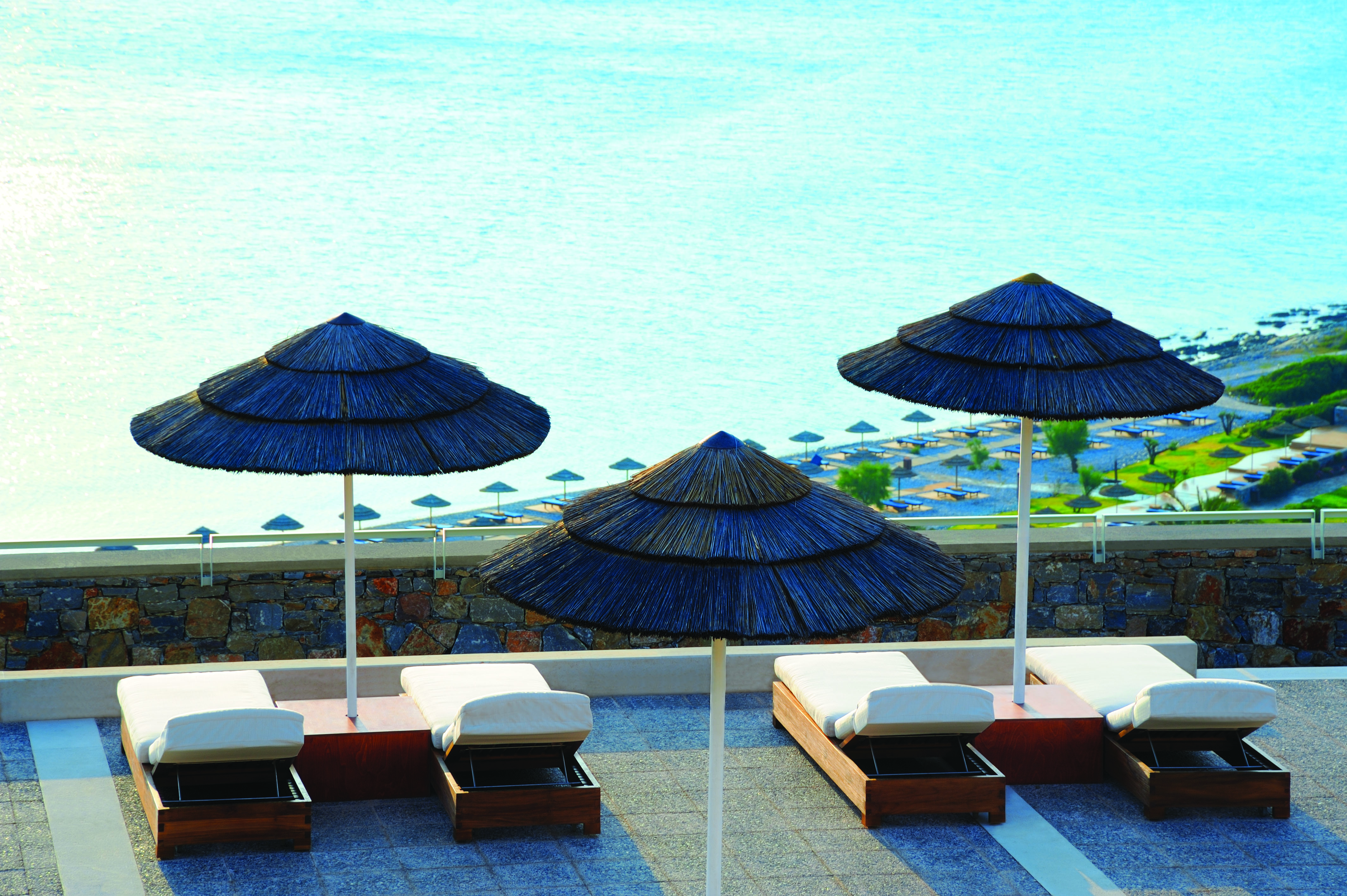 Blue Palace Greece balcony terrace sun loungers and palm umbrellas