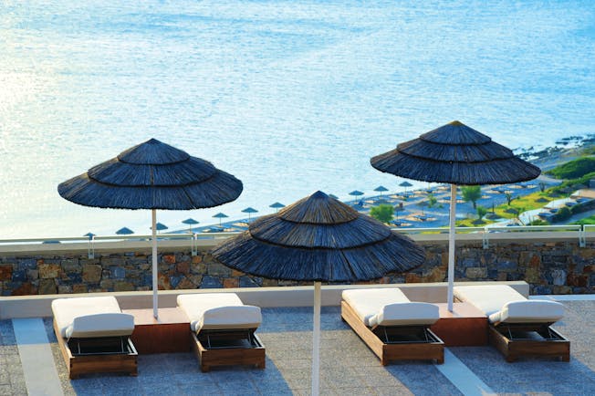 Blue Palace Greece balcony terrace sun loungers and palm umbrellas