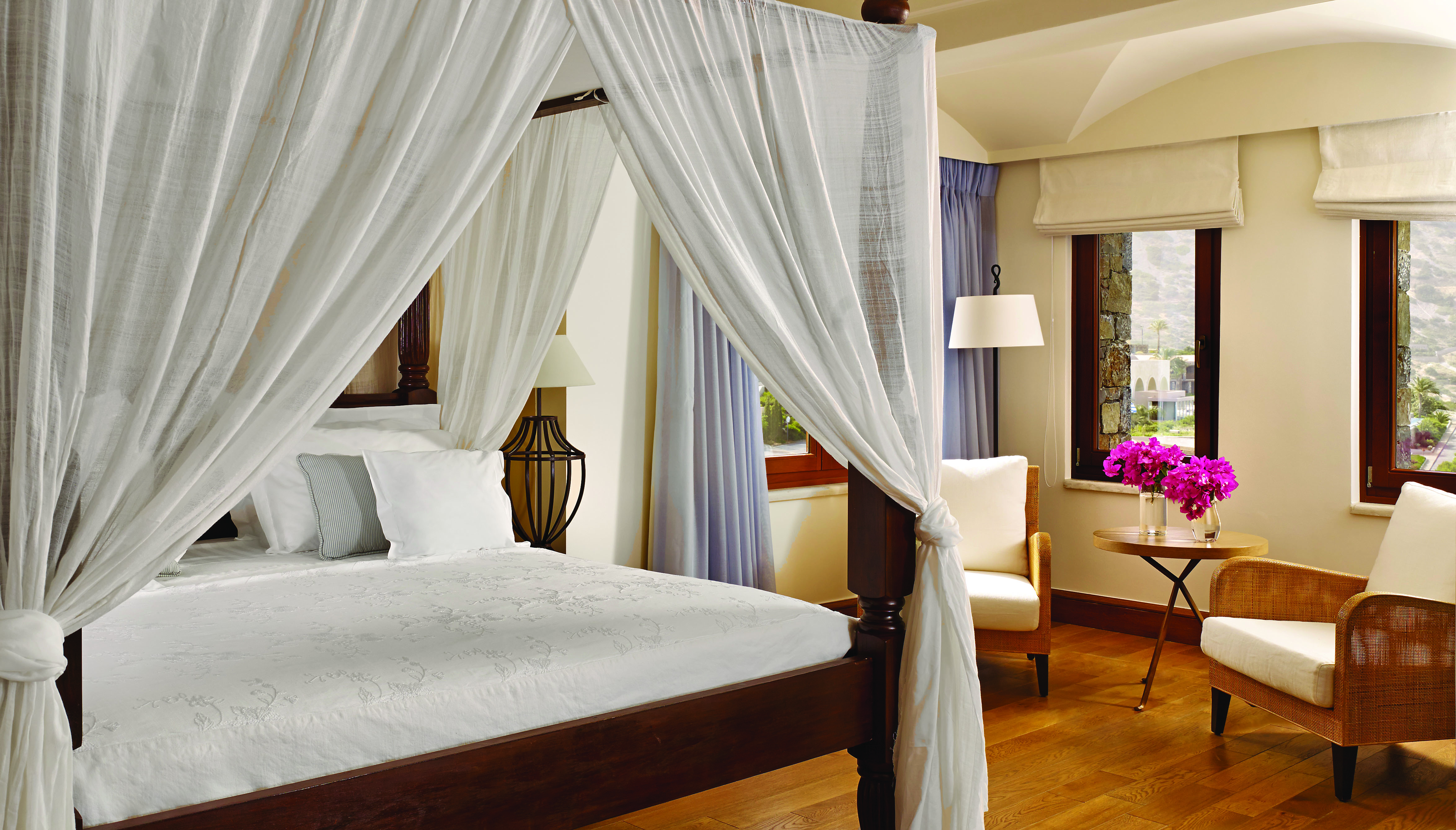 Blue Palace Greece blue villa bedroom with drapes and armchairs 