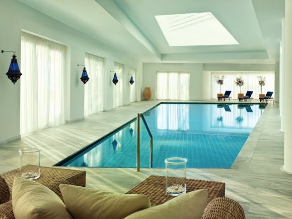 Blue Palace Greece indoor pool with blue lamps and loungers