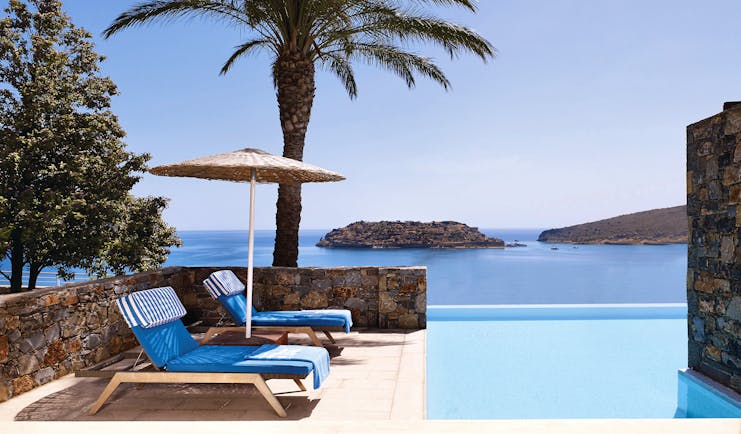Blue Palace Greece outdoor pool loungers and sea view