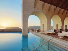 Blue Palace Greece outdoor pool decked seating area with large archways