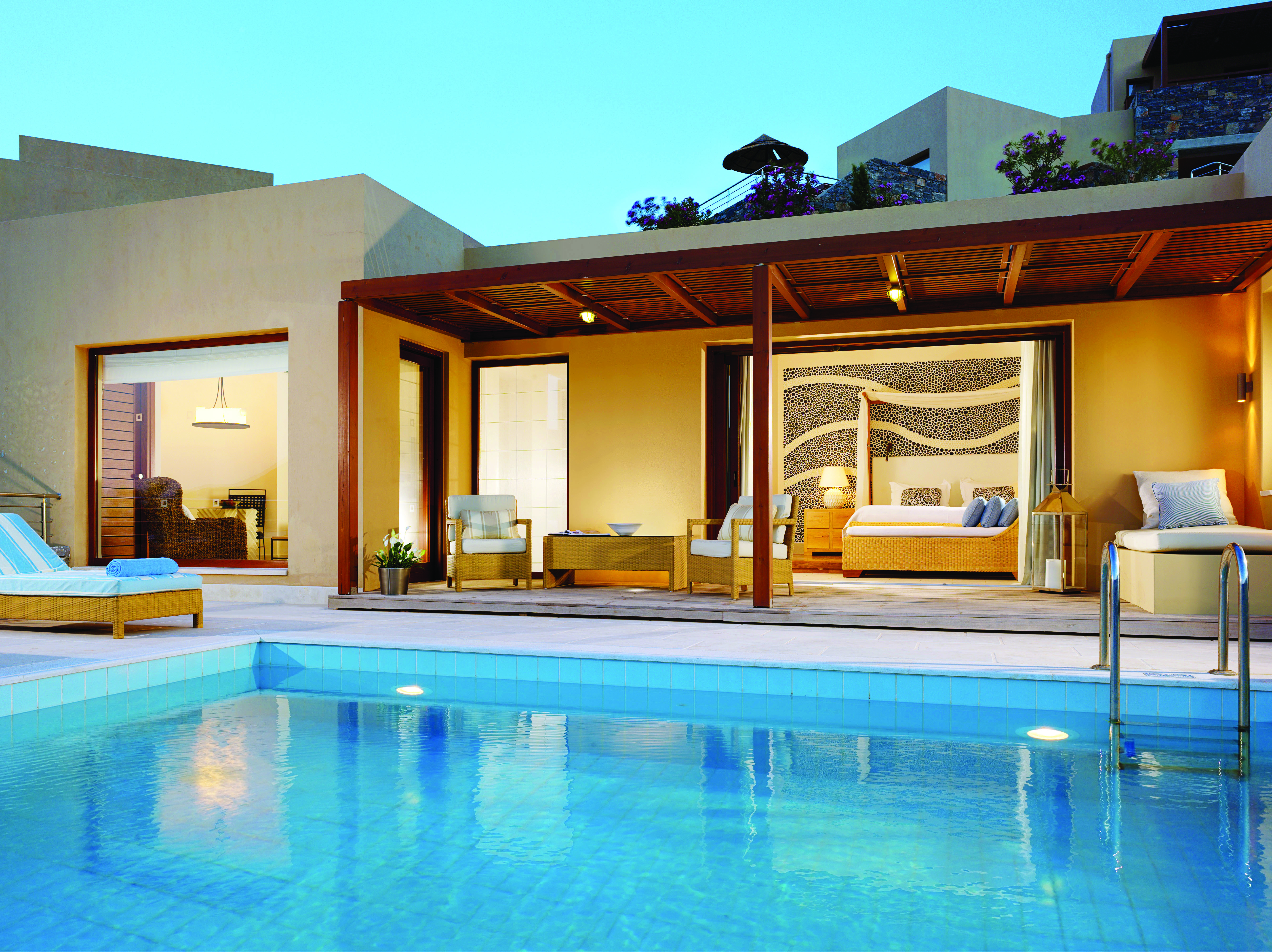 Blue Palace Greece suite pool sitting room with large windows and outdoor swimming pool with lounger