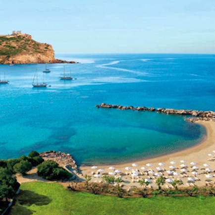 Cape Sounio Greece beach ocean sun loungers umbrellas boats on the waves