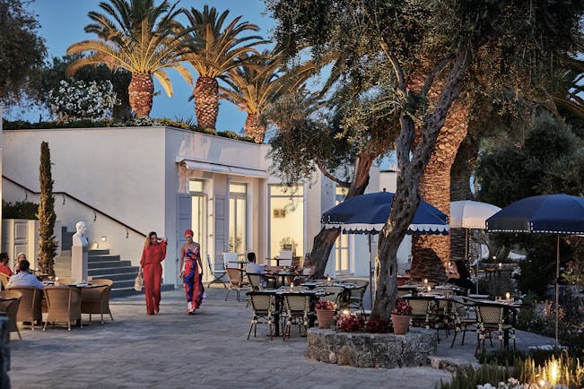 Courtyard dining at night with palm trees Corfu Imperial