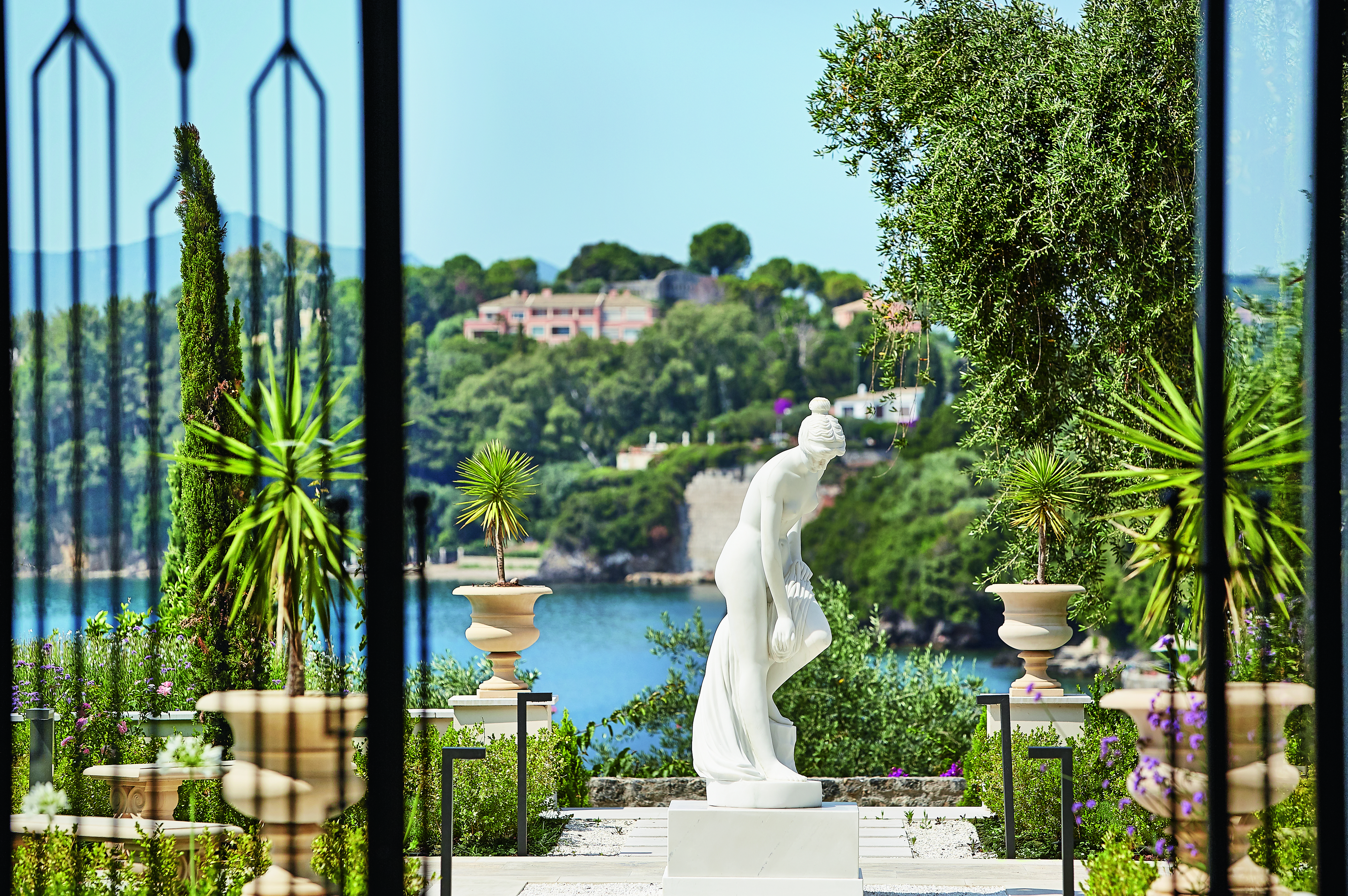 Gardens with palms and fountains and statues at the Corfu Imperial