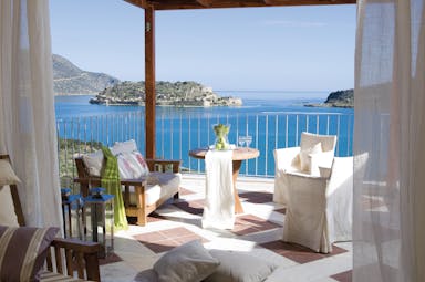 Domes of Elounda Greece balcony with sofa and chairs and sea view