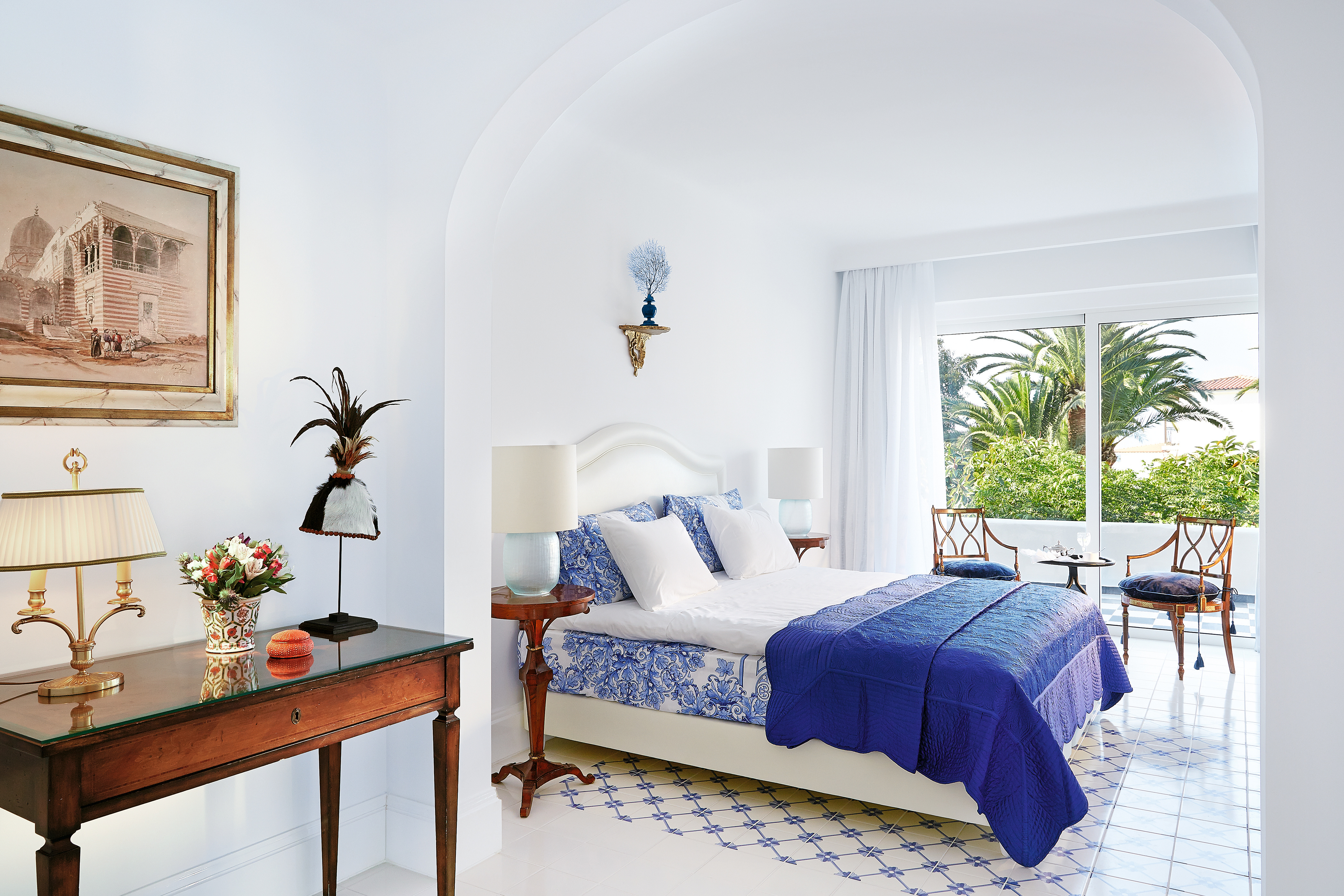 Grecotel Caramel Greece junior suite bedroom with blue and white tiled floor and balcony