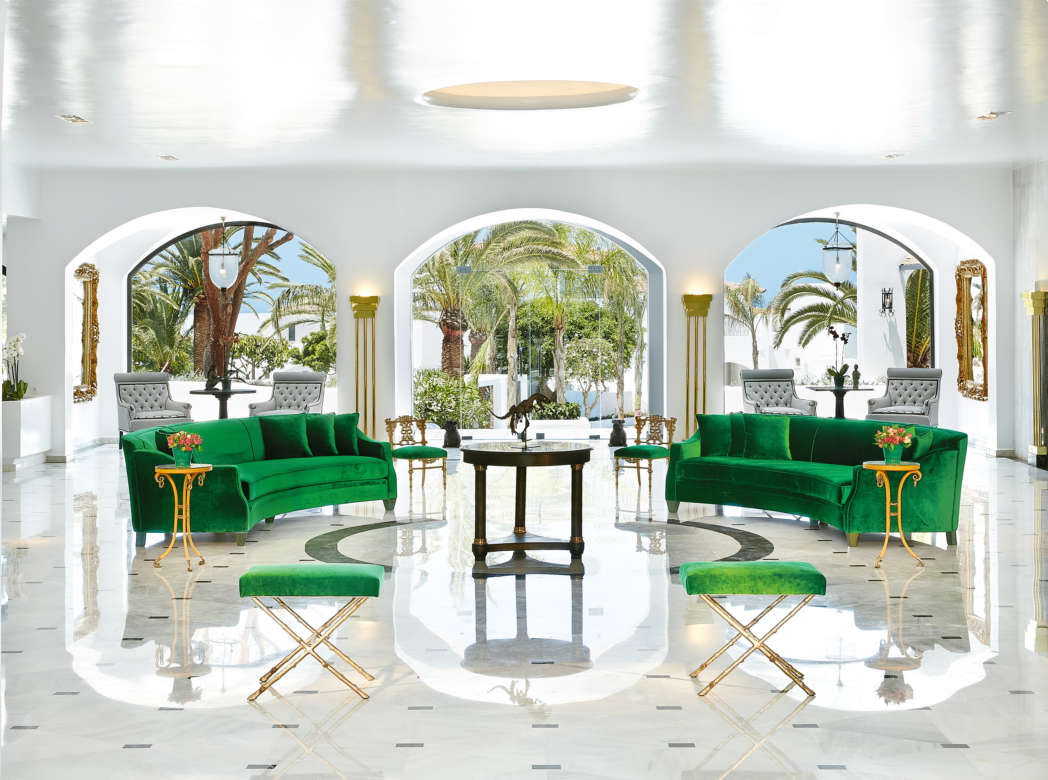 Grecotel Caramel Greece lounge area with two green sofas and archways with palm trees