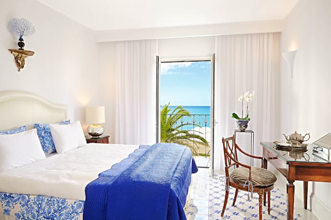 Grecotel Caramel Greece suite bedroom blue and white tiled floor desk and sea view balcony