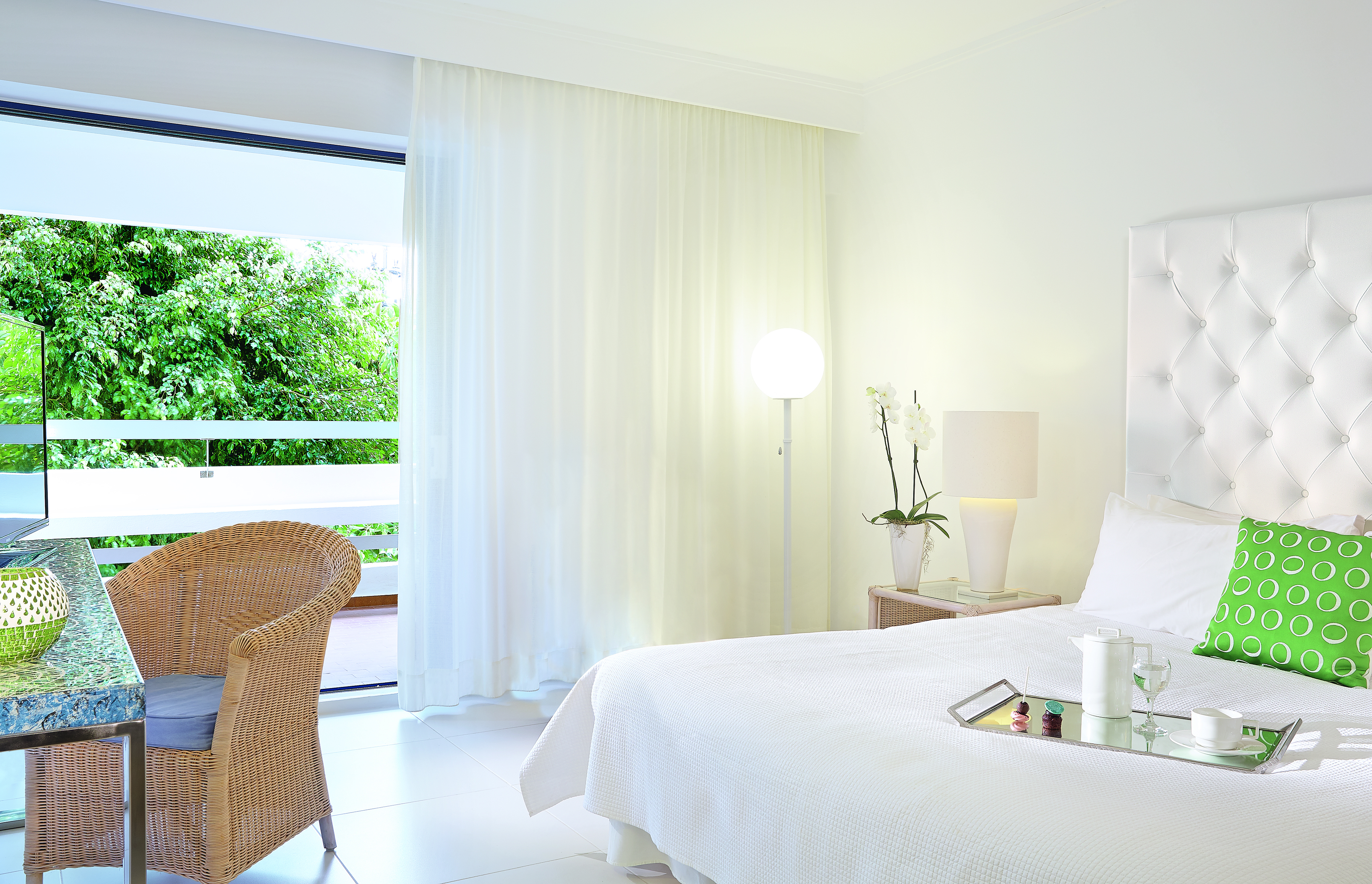 Grecotel White Palace whte room with rattan chair