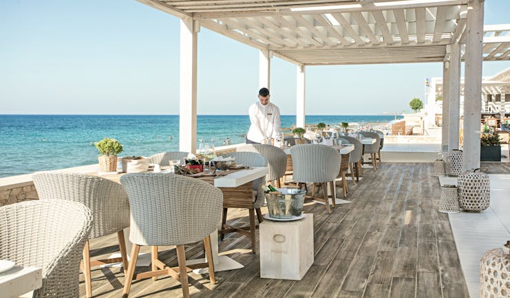 Grecotel White Palace seaside restaurant decking white chairs