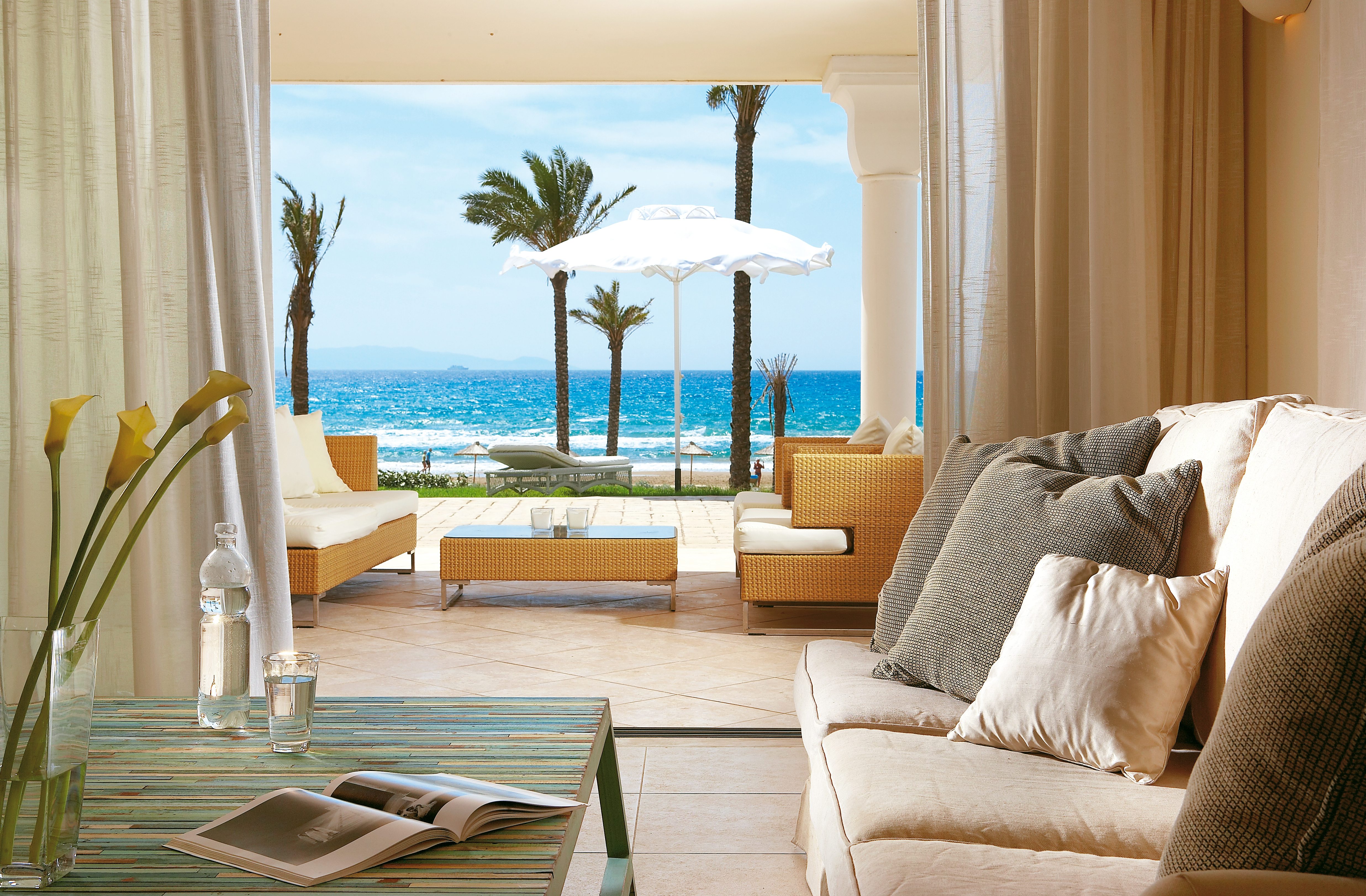 Grecotel Mandola Rosa Greece beach villa sitting area with open doors onto terrace and beach