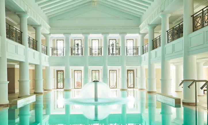 Grecotel Mandola Rosa Greece indoor pool roman style white building fountain