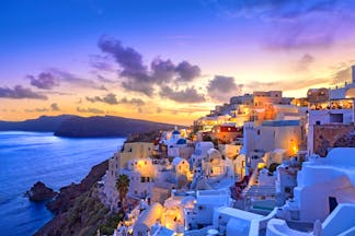 Sunset over the famous white houses and buildings on Santorini's coastline