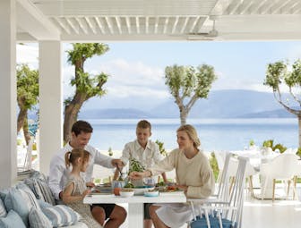 Ikos Dassia Greece Ouzo restaurant family eating outside with sea view