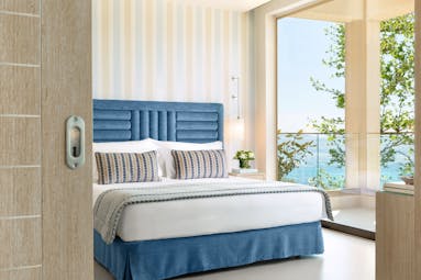 Ikos Oceania Greece deluxe family suite bedroom with balcony and sea views