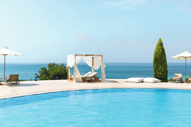 Ikos Oceania Greece outdoor pool with white cabana lounger