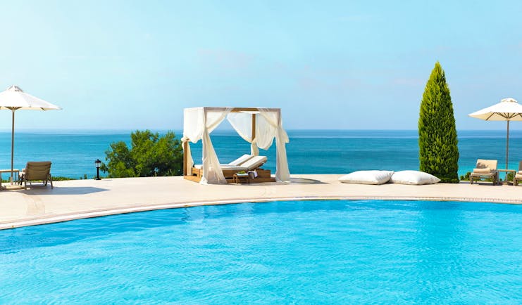 Ikos Oceania Greece outdoor pool with white cabana lounger