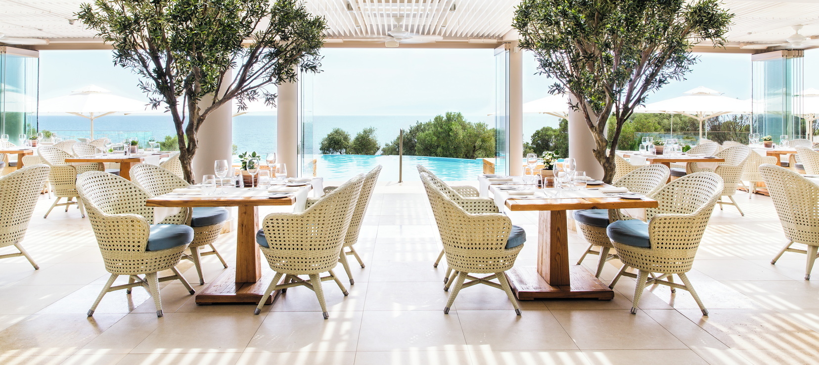 Ikos Oceania Greece Provence restaurant outdoor veranda dining area with pool and sea views