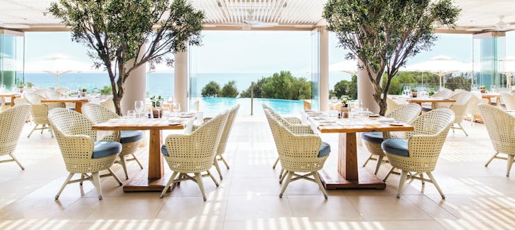 Ikos Oceania Greece Provence restaurant outdoor veranda dining area with pool and sea views