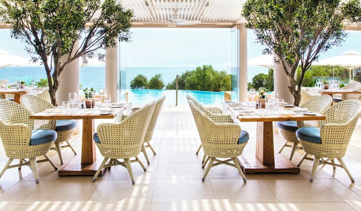 Ikos Oceania Greece Provence restaurant outdoor veranda dining area with pool and sea views