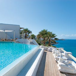 Mykonos Blu Greece Grecotel outdoor pool with covered deck lounging area and sea view