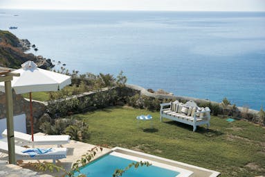 Mykonos Blu Greece Grecotel private terrace view pool with sun loungers and umbrella garden area and sofa