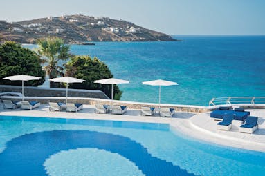 Mykonos Grand Hotel Greece exterior pool with sun loungers looking over the sea