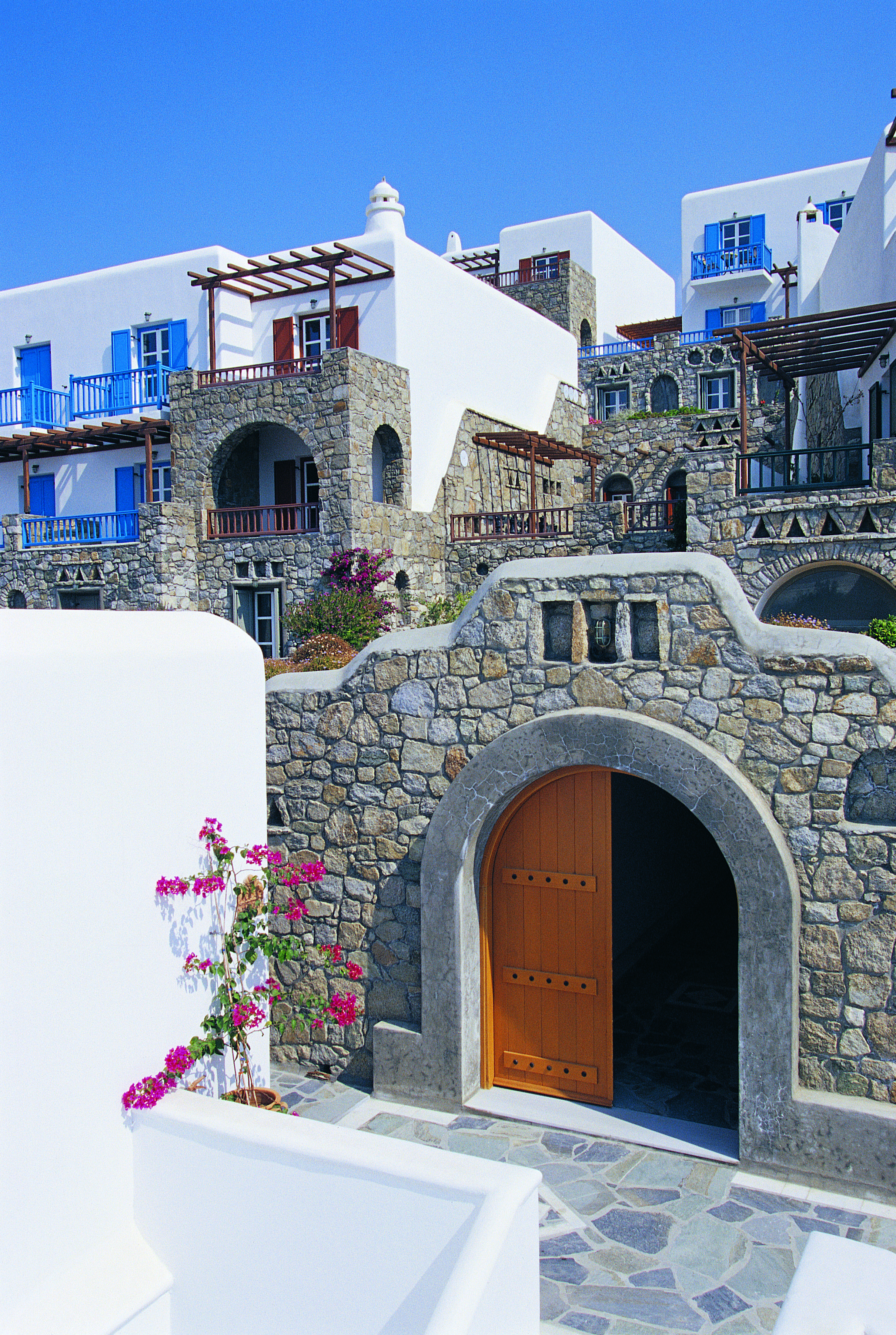 Mykonos Grand Hotel Greece exterior white and stone buildings with blue shutters and balconies