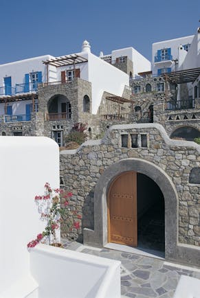 Mykonos Grand Hotel Greece exterior white and stone buildings with blue shutters and balconies