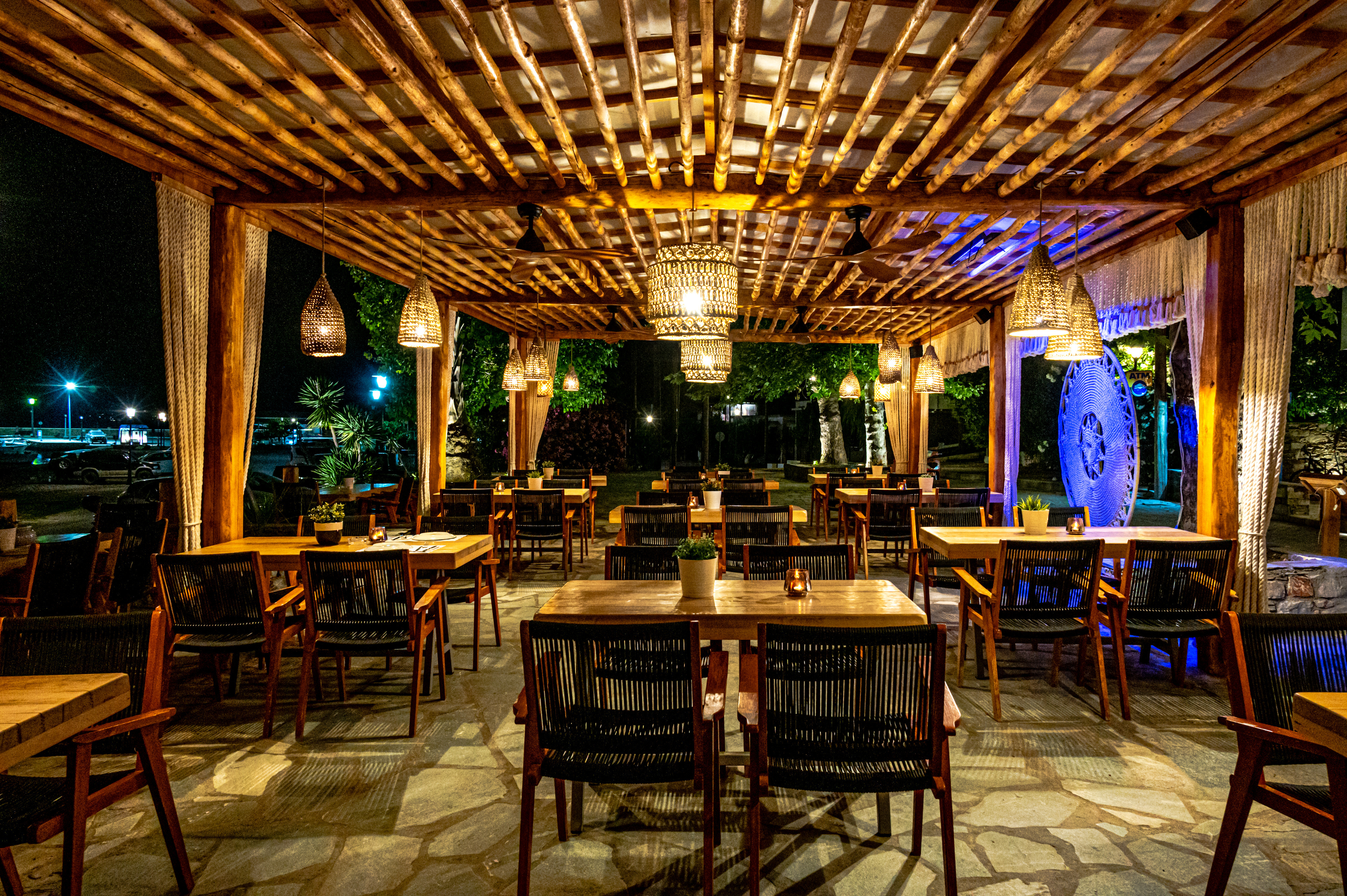 Natura Luxury Boutique Hotel restaurant with wood furnishings and canopy and stone floors and low, warm lighting
