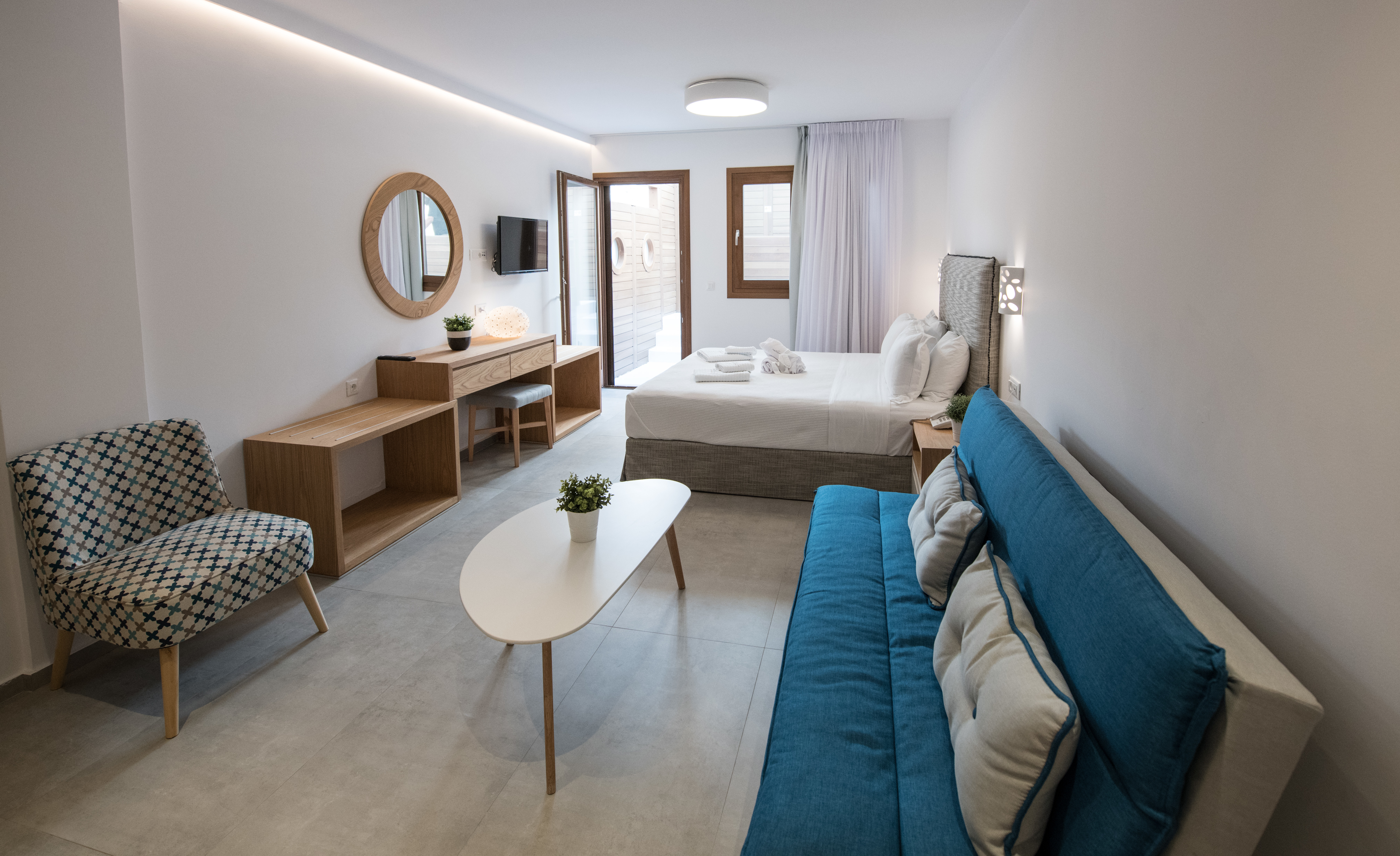 Natura Luxury Boutique Hotel Mamma Mia Suite with blue sofa bed and minimalist furnishings