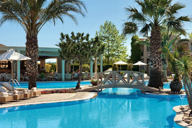 Porto Sani Greece outdoor pool with bridge and palm trees
