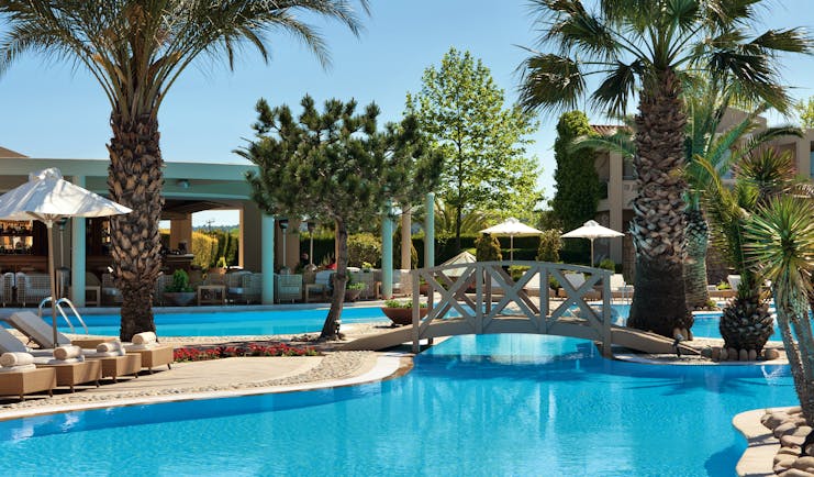 Porto Sani Greece outdoor pool with bridge and palm trees